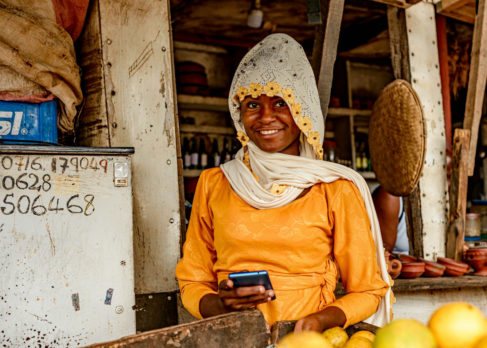 Market vendor checking her phone for a loan offer